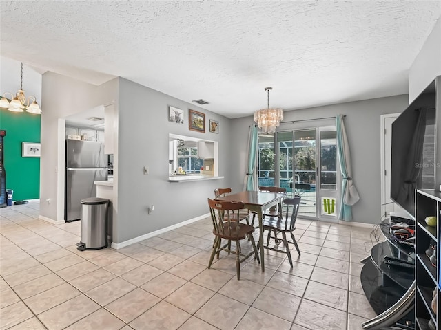 dining room featuring light tile patterned floors, visible vents, a chandelier, and baseboards