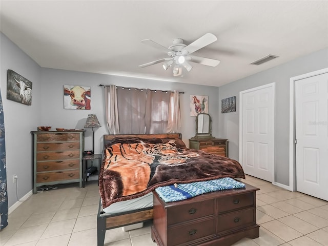 bedroom with light tile patterned floors, ceiling fan, visible vents, and baseboards