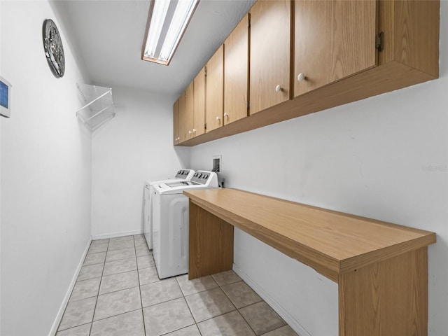 clothes washing area featuring light tile patterned floors, washing machine and clothes dryer, cabinet space, and baseboards