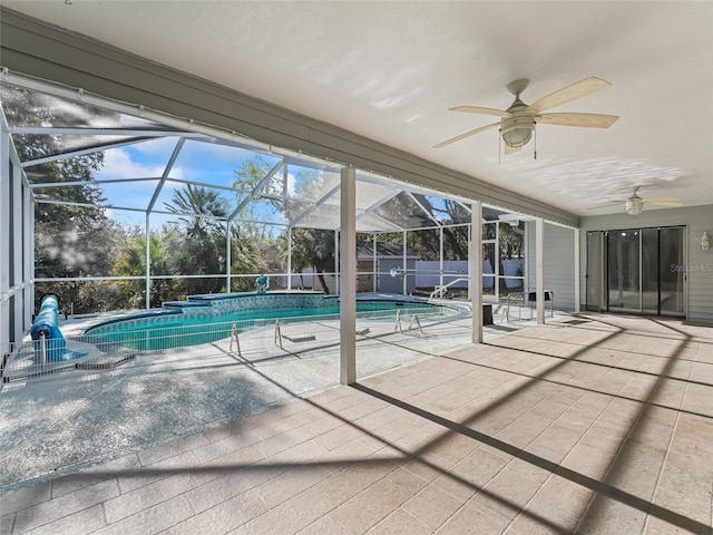 view of pool with glass enclosure, ceiling fan, a patio area, and a fenced in pool