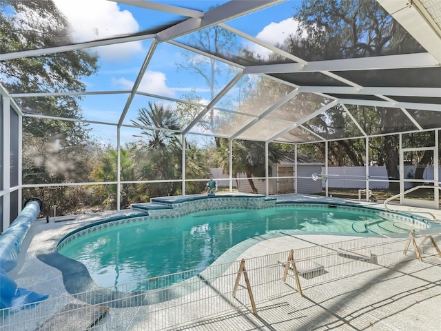 view of swimming pool with a fenced in pool, a storage unit, fence, a lanai, and an outdoor structure