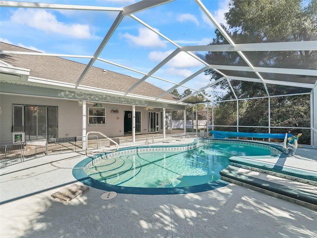 view of swimming pool featuring a patio area, glass enclosure, and a covered pool