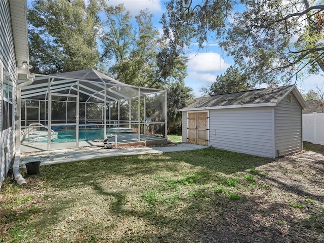 view of yard featuring a storage unit, glass enclosure, fence, an outdoor pool, and an outdoor structure