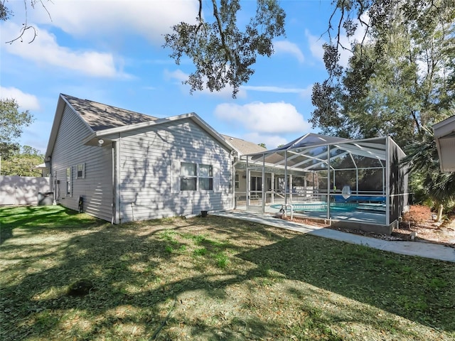 back of house with a patio, a lawn, fence, a lanai, and an outdoor pool