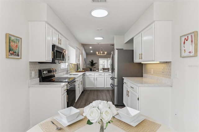 kitchen featuring decorative backsplash, stainless steel appliances, light countertops, white cabinetry, and a sink