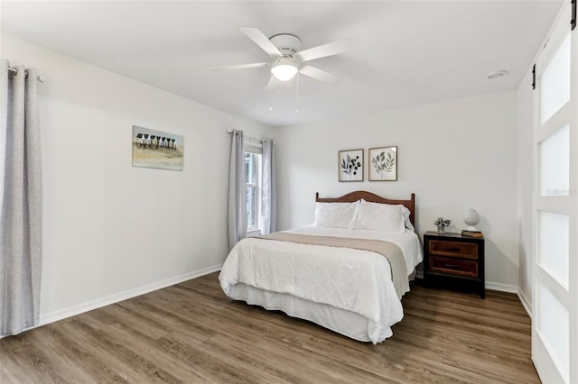 bedroom featuring ceiling fan, wood finished floors, and baseboards