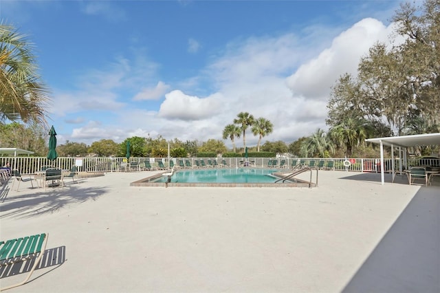 pool with fence and a patio