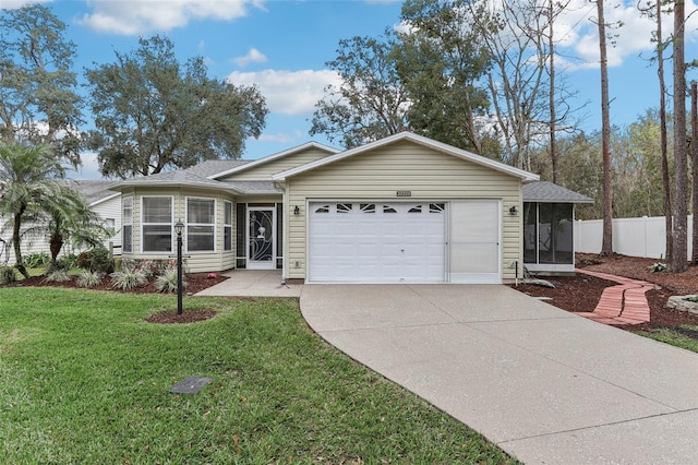 single story home featuring a garage, fence, a sunroom, concrete driveway, and a front yard