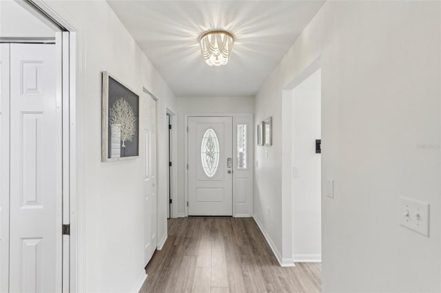 entryway with light wood-type flooring and baseboards