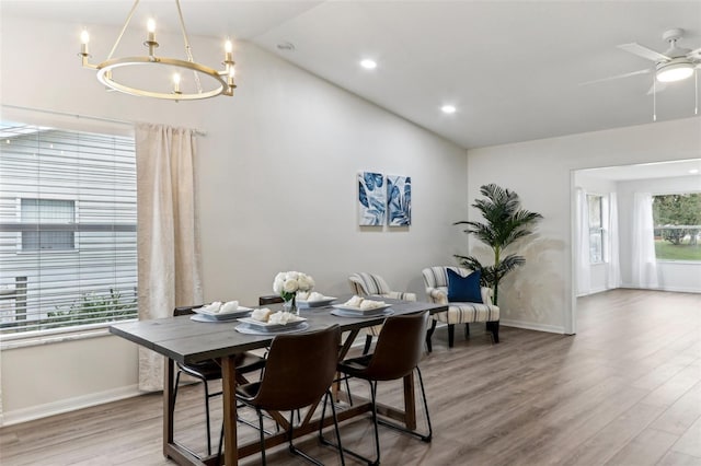 dining area with lofted ceiling, baseboards, and wood finished floors