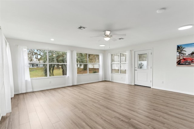 unfurnished sunroom with a ceiling fan and visible vents