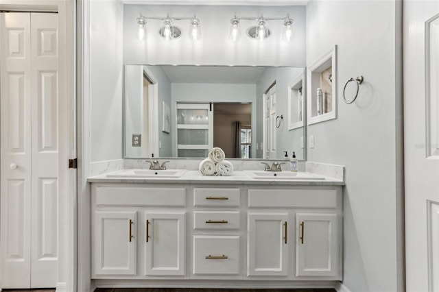 bathroom featuring a sink, double vanity, and a closet