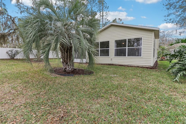 exterior space featuring a lawn and fence