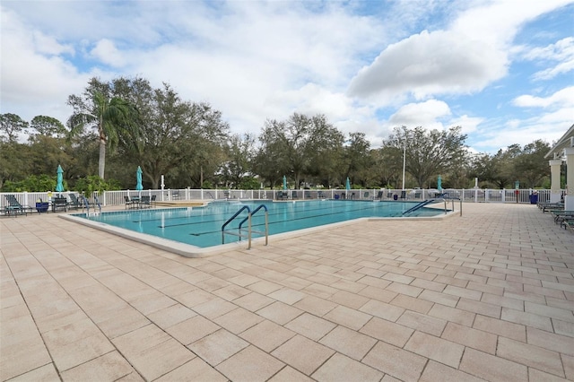 view of pool with a patio area and fence