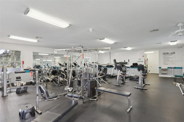 exercise room with visible vents and a textured ceiling