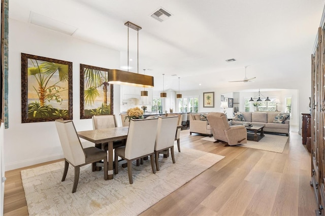 dining room with visible vents, light wood-style flooring, and baseboards