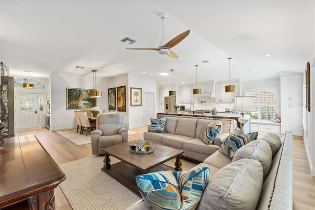 living room with light wood-style floors, recessed lighting, visible vents, and a ceiling fan