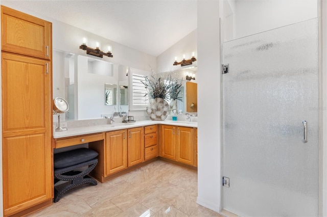 bathroom with lofted ceiling, double vanity, a stall shower, and a sink