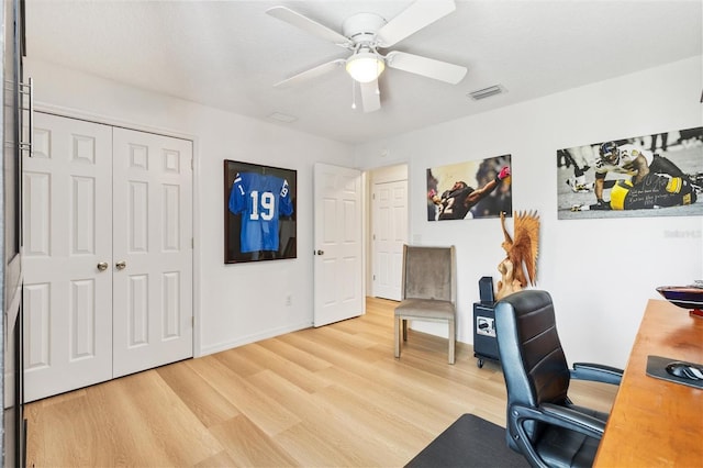 office area featuring baseboards, light wood-type flooring, visible vents, and a ceiling fan