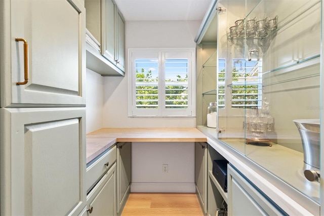 kitchen featuring light wood-style floors, a wealth of natural light, light countertops, and gray cabinetry