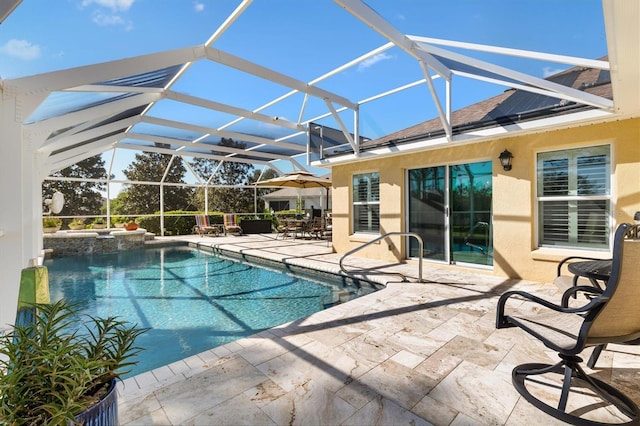 view of pool featuring a lanai, a pool with connected hot tub, and a patio