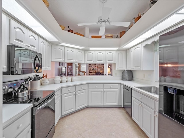 kitchen with white cabinets, electric range oven, light countertops, black microwave, and stainless steel dishwasher