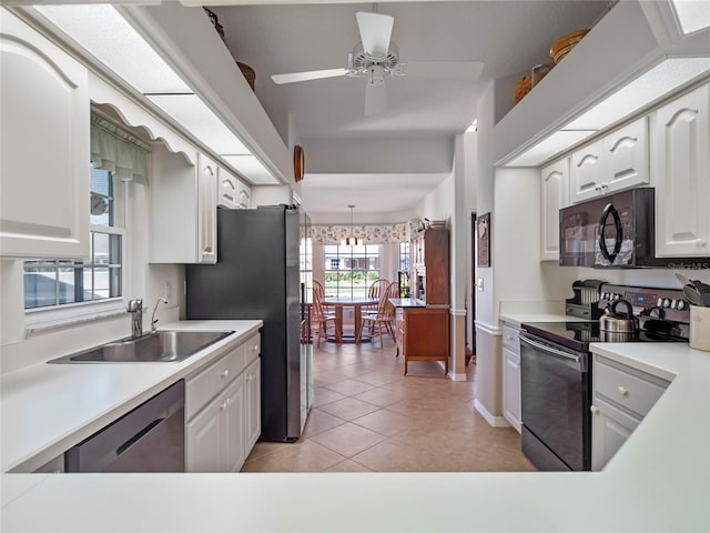 kitchen with light countertops, appliances with stainless steel finishes, white cabinetry, a sink, and light tile patterned flooring