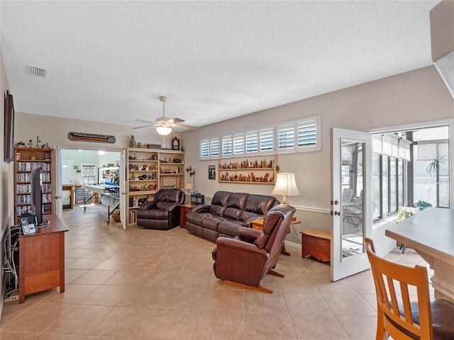 living room with light tile patterned floors, a ceiling fan, and a wealth of natural light