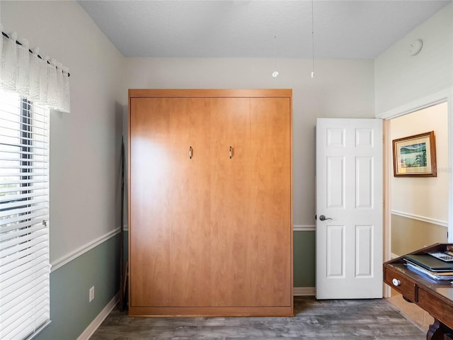 bedroom with baseboards and wood finished floors