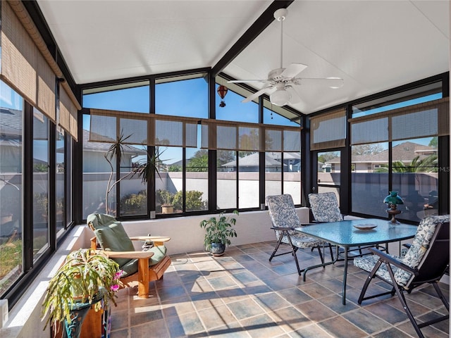 sunroom featuring vaulted ceiling with beams and ceiling fan