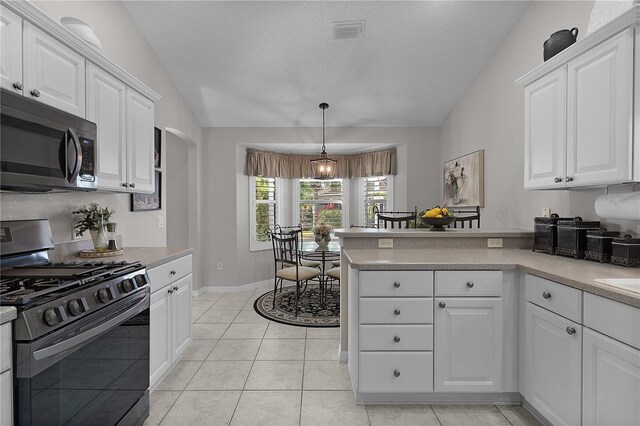 kitchen with lofted ceiling, visible vents, white cabinetry, and appliances with stainless steel finishes