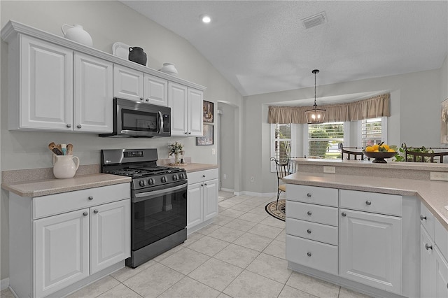kitchen featuring lofted ceiling, light countertops, visible vents, appliances with stainless steel finishes, and white cabinetry