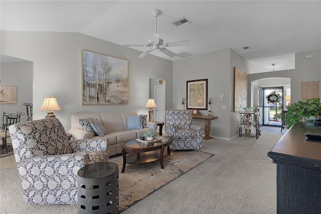 carpeted living area with vaulted ceiling, visible vents, arched walkways, and ceiling fan