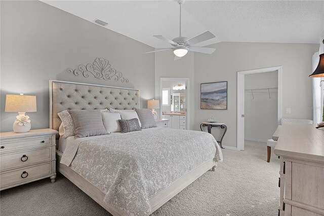 bedroom featuring carpet, a spacious closet, vaulted ceiling, visible vents, and a closet