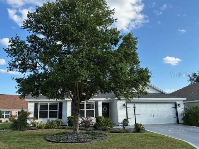 view of front of home featuring an attached garage, a front yard, and concrete driveway
