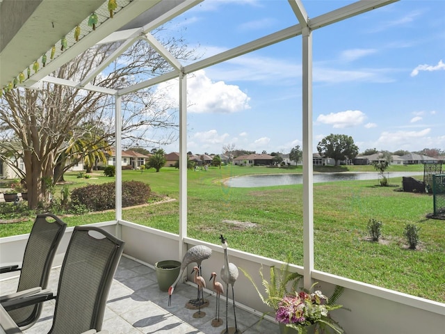 unfurnished sunroom featuring a water view and a residential view