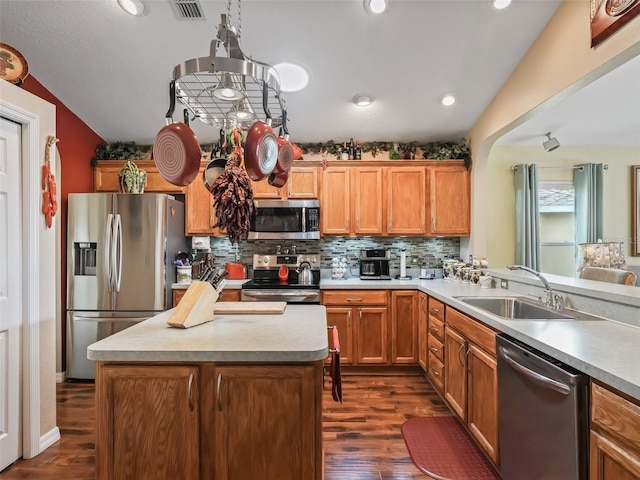 kitchen with stainless steel appliances, dark wood-type flooring, a sink, and backsplash