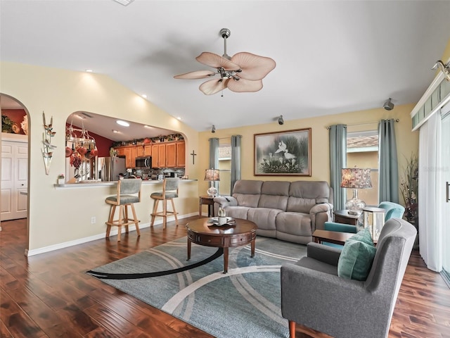 living area with lofted ceiling, ceiling fan, wood finished floors, and baseboards