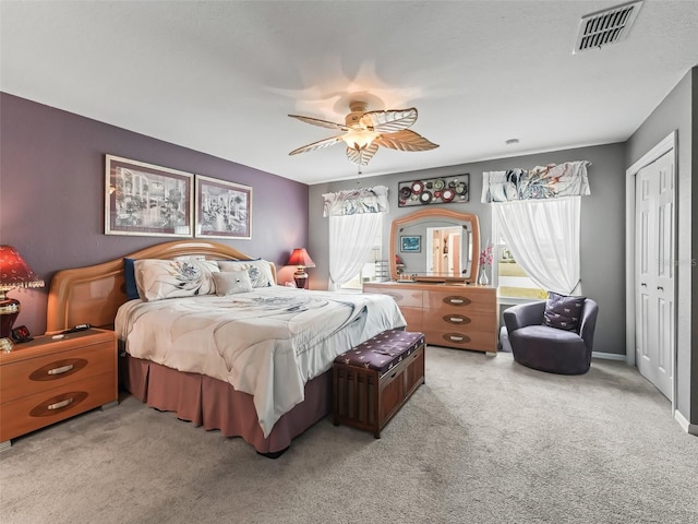 bedroom with baseboards, visible vents, ceiling fan, carpet floors, and a closet