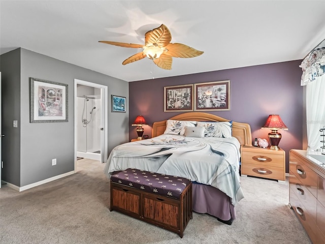 carpeted bedroom featuring ensuite bathroom, a ceiling fan, and baseboards