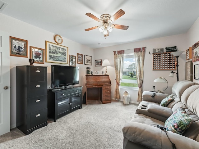 living area featuring light carpet and a ceiling fan