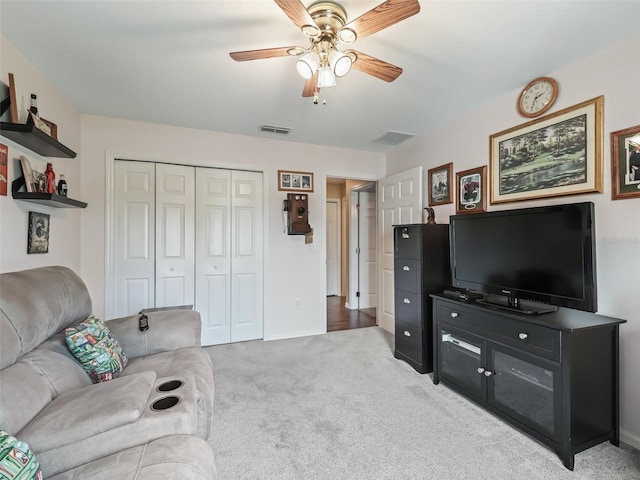 living room with light carpet, ceiling fan, and visible vents