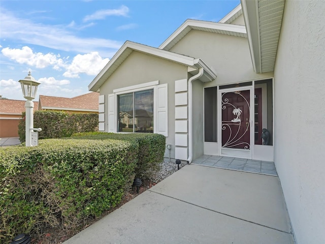 doorway to property featuring stucco siding