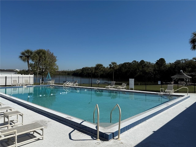 community pool with fence and a patio