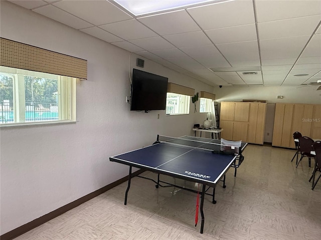 rec room with a wealth of natural light, a paneled ceiling, and baseboards