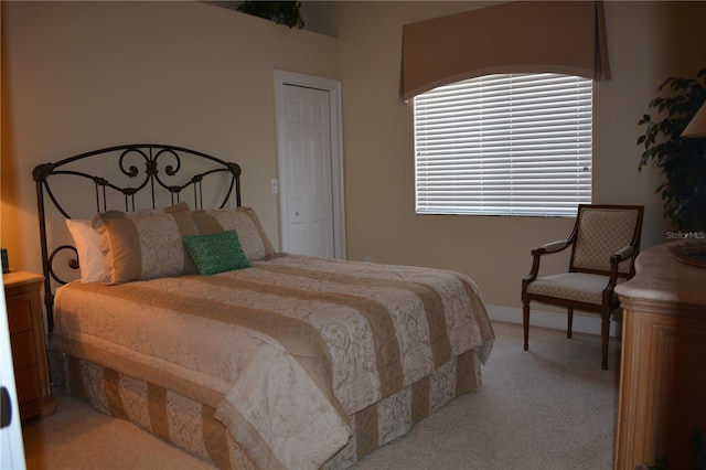 bedroom with baseboards and light carpet