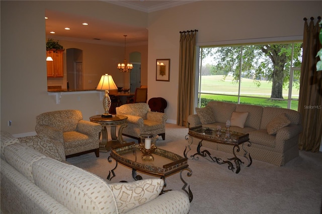 carpeted living area featuring baseboards, recessed lighting, arched walkways, ornamental molding, and a notable chandelier