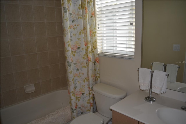 full bath featuring toilet, shower / bath combo with shower curtain, and vanity