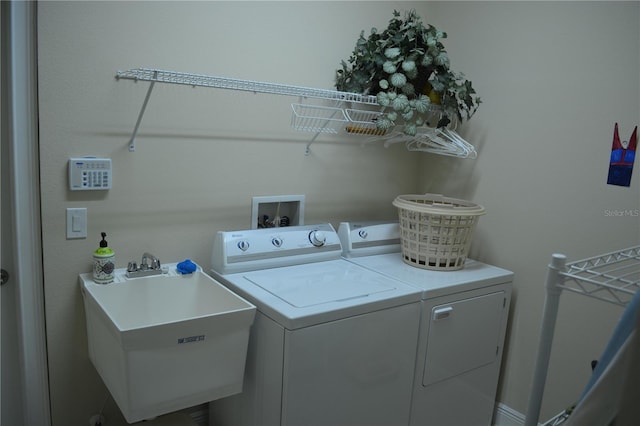 laundry area with a sink, washing machine and dryer, and laundry area