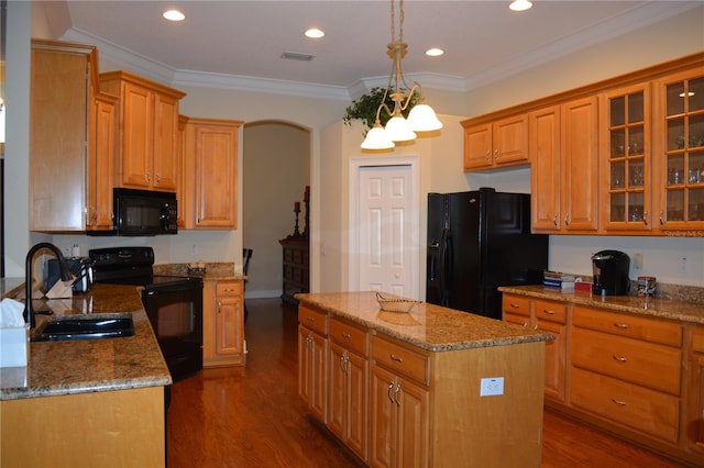 kitchen featuring light stone counters, a kitchen island, dark wood finished floors, ornamental molding, and black appliances